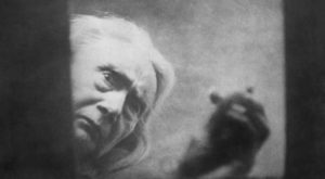 The blood-drinking witch (Henriette Gerard) peers into hero Allan Gray (Nicholas de Gunzburg)'s coffin in Carl Th. Dreyer's Vampyr (1932)