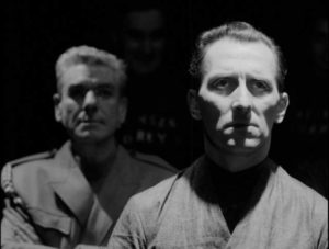 O'Brien (Abdre Morell) has his eye on Winston Smith (Peter Cushing) in Rudolph Cartier's Nineteen Eighty-Four (1954)