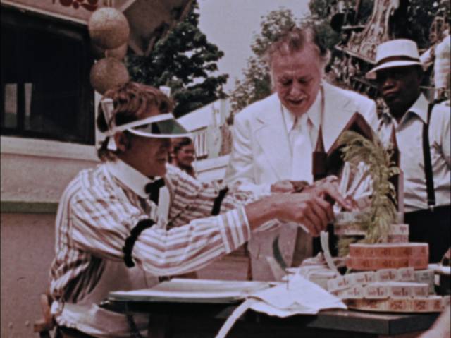 An impatient tout (S. William Hinzman) sells the elderly man (Lincoln Maazel) tickets to life's attractions in George A. Romero's The Amusement Park (1975)