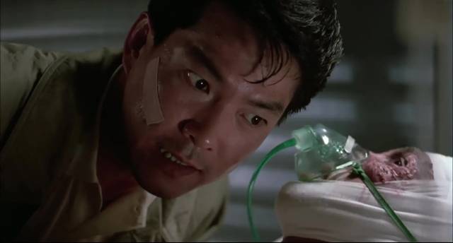 Hsiang Ming (Yuen Biao) questions a dying man in Alfred Cheung's On the Run (1988)