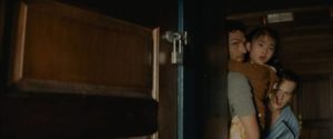 Andrew (Ben Aldridge), Eric (Jonathan Groff) and Wen (Kristen Cui) hear strangers breaking in in M. Night Shyamalan's Knock at the Cabin (2023)