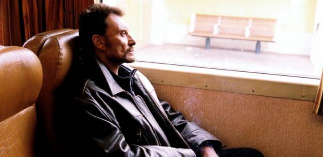 Milan (Johnny Hallyday) arrives in town to plan a bank robbery in Patrice Leconte's Man on the Train (2002)
