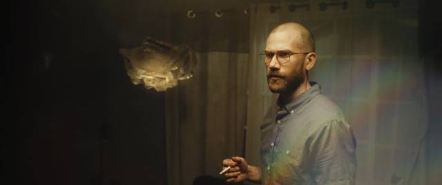 John Daniels (Aaron Moorhead) is intrigued by a floating crystal in Justin Benson & Aaron Moorhead's Something in the Dirt (2022)