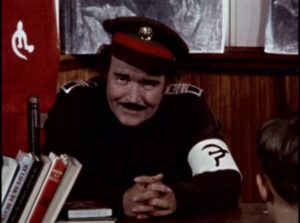 Commissar (Gene McFall) tells school kids the state is now their God in Ron Ormond's If Footmen Tire You, What Will Horses Do? (1971)