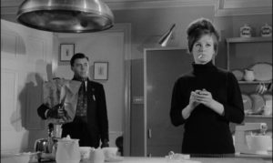Barrett (Dirk Bogarde) introduces his "sister" Vera (Sarah Miles) into the house in Joseph Losey's The Servant (1963)