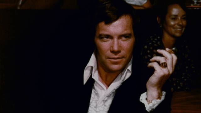 Matt Stone (William Shatner) is attentive to a nightclub dancer's performance in William Grefé's Impulse (1974)