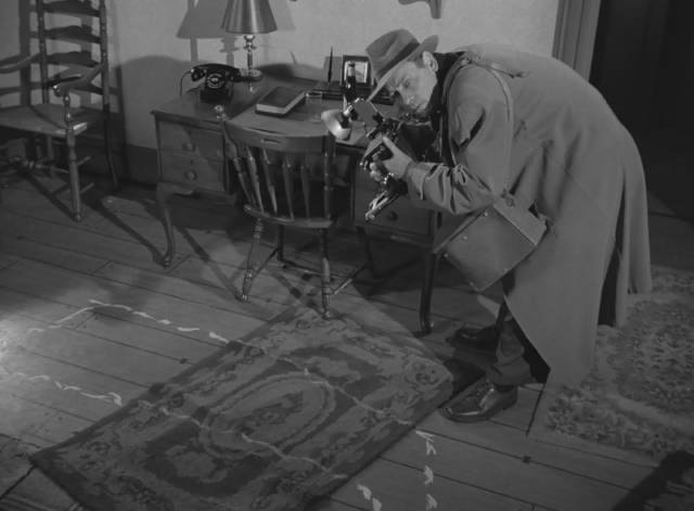 A police photographer takes pictures of the crime scene in Harry Essex's I, the Jury (1953)