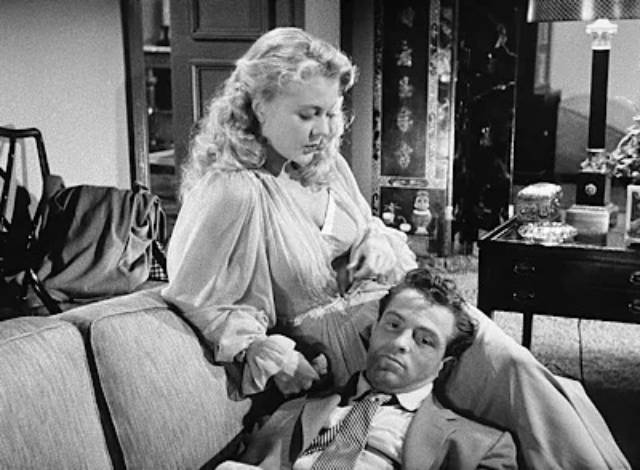 Psychologist Charlotte Manning (Peggie Castle) comforts Mike Hammer (Biff Elliot) after yet another vicious beating in Harry Essex's I, the Jury (1953)