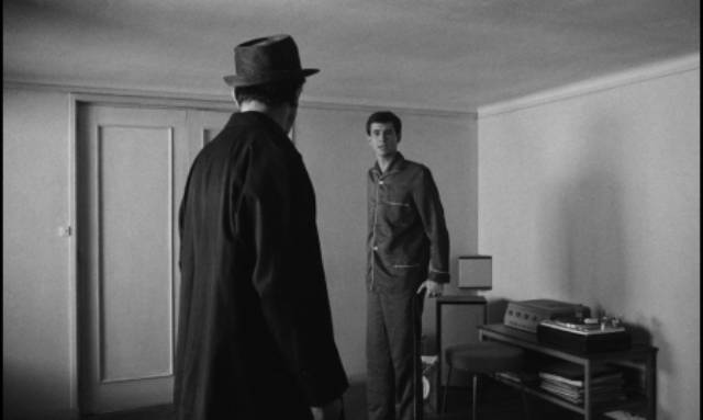 Josef K. (Anthony Perkins) is rudely awoken by a policeman (Arnoldo Foà) in Orson Welles's The Trial (1962)