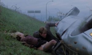James Ballard (James Spader) pulls Catherine (Deborah Kara Unger) from the wreck which leaves her unharmed in David Cronenberg's Crash (1996)