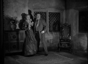 The false Sir Percival Glyde (Tod Slaughter) is interrupted in the midst of assaulting Marian Fairlie (Hilary Eaves) in George King's Crimes at the Dark House (1940)