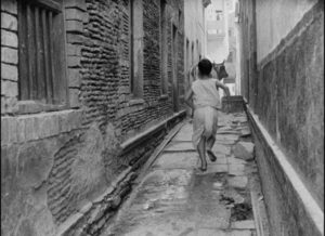 Young Apu (Pinaki Sengupta) runs wild in the streets of Benares in Satyajit Ray's Aparajito (1956)