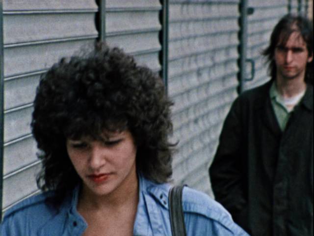 Frankie (Rick Giovinazzo) reluctantly decides to rob a woman (Mary Cristadoro) on the street in Buddy Giovinazzo's Combat Shock (1986)