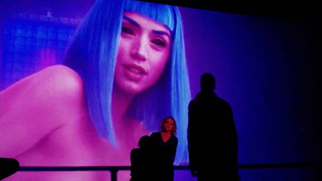 Filmmaker Nina Menkes lectures in front of a sexually-coded image from Blade Runner 2049 in Brainwashed: Sex-Camera-Power (2022)