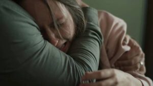 Lara Levonde (Georgia Eyers) is comforted by husband Ron (Dan Ewing) who believes she's possessed in Nick Kozakis’ Godless: The Eastfield Exorcism (2023)