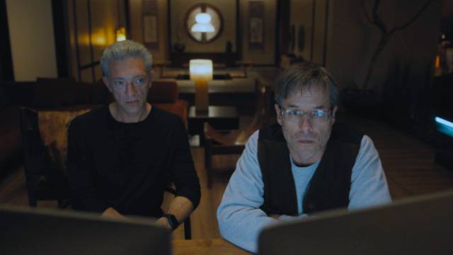 Maury Entrekin (Guy Pearce) attempts to crack the encryption outsiders have installed in the GraveTech software in David Cronenberg's The Shrouds (2024)