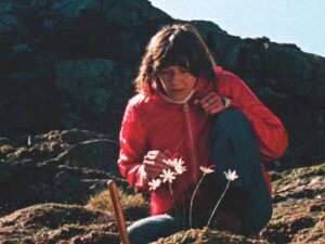 The Volunteer (Mary Woodvine)'s task is daily observation of a particular plant growing on a cliff edge in Mark Jenkin's Enys Men (2022)