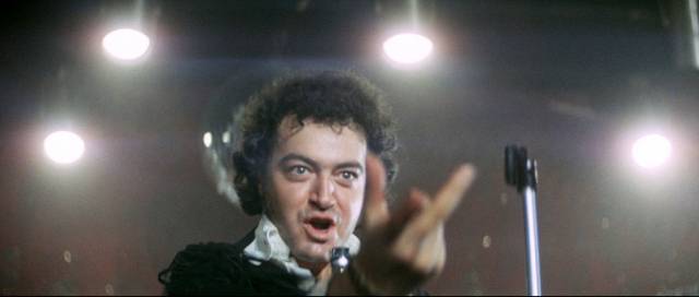 Crooner Jack Daniels (Alan Lake) will soon be left behind by his band-mates in Richard Loncraine's Flame (1975)