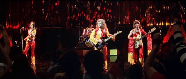The band's newly forged glam identity leads to popular success ... for a while in Richard Loncraine's Flame (1975)